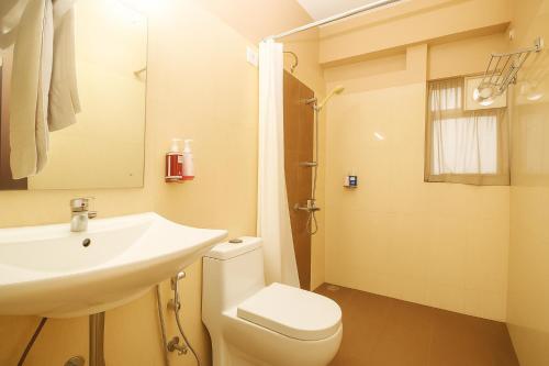 a bathroom with a sink and a toilet and a shower at Central Courtyard Boutique Hotel in Siliguri