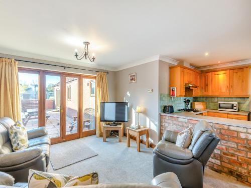 un salon avec deux canapés et une télévision dans l'établissement Chestnut Cottage - Uk45580, à Maltby le Marsh