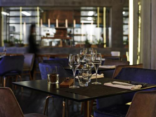 a table with wine glasses on it in a restaurant at Pullman Sao Paulo Vila Olimpia in Sao Paulo