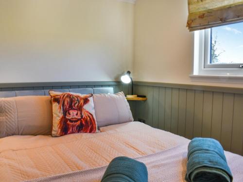 a bedroom with a bed with a cow pillow on it at Meadows View Shepherd's Hut in Cockermouth