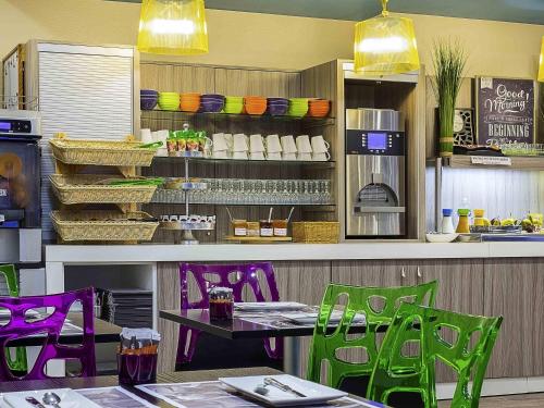 a restaurant with purple and green chairs and a table at ibis Styles St Gilles Croix de Vie centre-ville in Saint-Gilles-Croix-de-Vie