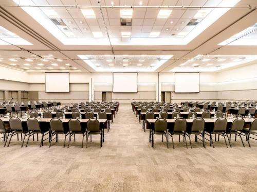 a large room with rows of tables and chairs at Grand Mercure Sao Paulo Vila Olimpia in Sao Paulo
