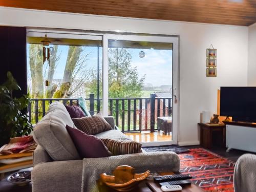 Una sala de estar con un sofá y una gran puerta corrediza de vidrio. en Valley View Lodge, en Bideford