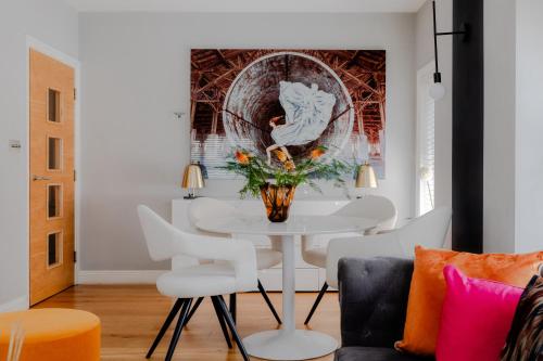 a dining room with a white table and white chairs at Cool Covent Garden Theatre Design Hub for Families Friends Couples in London