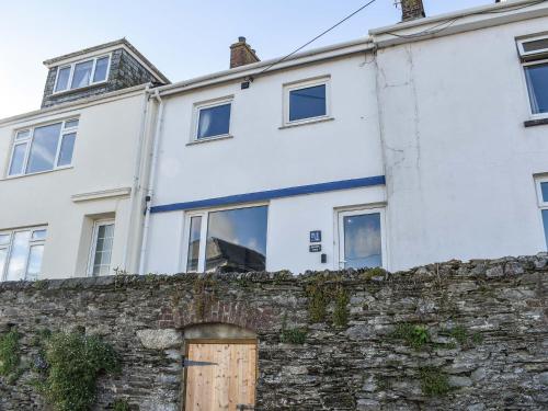 a white house behind a stone wall at Helen's View in Torpoint