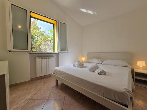 a bedroom with a large white bed with a window at Eucalipto - By Ligooria in Magliolo