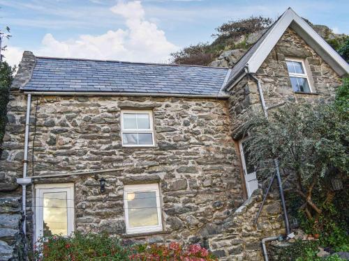 an old stone house with a slate roof at Bwth Carron in Barmouth