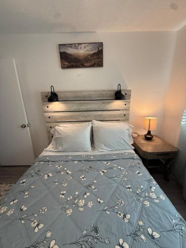 a bedroom with a bed with a blue comforter at Emmanuel Fulton Park Condominium in Tulsa