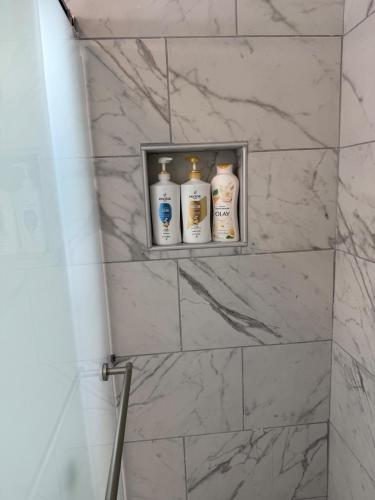 a shelf in a bathroom with four bottles on it at Emmanuel Fulton Park Condominium in Tulsa