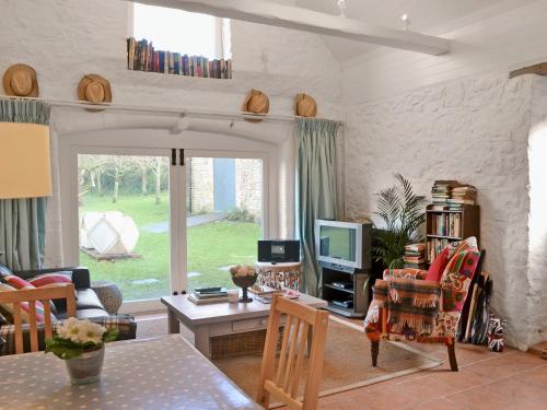 ein Wohnzimmer mit Sofa und Fernseher in der Unterkunft Ragwood Cottage in Weare