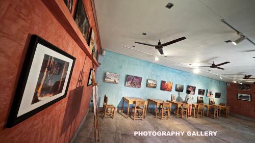 a room with chairs and paintings on a wall at Lodge Hara Oasis in Agdz
