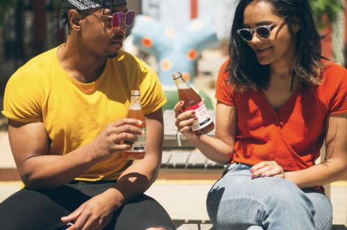 a man and woman sitting on a bench holding beer bottles at Cool Covent Garden Theatre Design Hub for Families Friends Couples in London