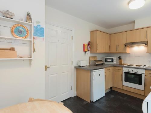 a kitchen with wooden cabinets and a white door at Hydan Creek Gardens in Wootton Bridge