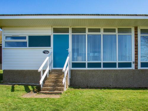 a house with a blue door and some stairs at Chalet 54 in Cromer
