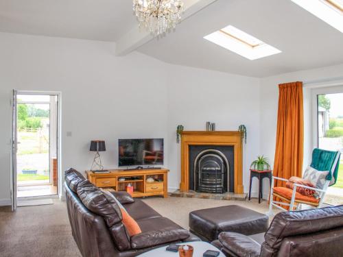 a living room with leather furniture and a fireplace at The Crofts in Winsford