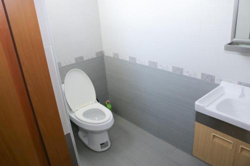 a bathroom with a toilet and a sink at Akwaaba Retreats in Tema