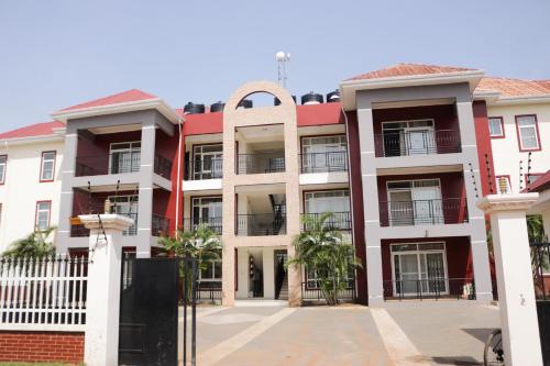 a red and white building with palm trees in front of it at Akwaaba Retreats in Tema
