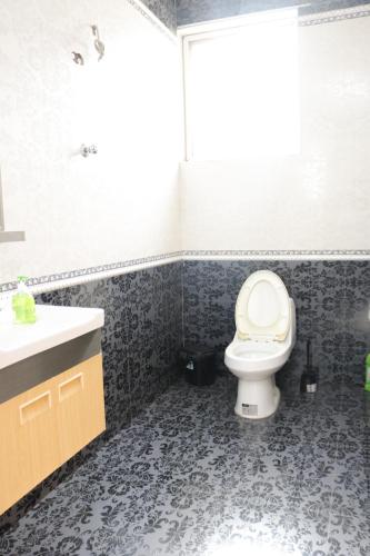 a bathroom with a toilet and a sink at Akwaaba Retreats in Tema