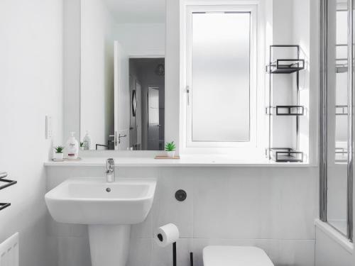 a white bathroom with a sink and a mirror at Home Choi in Culloden