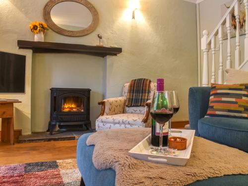 sala de estar con sofá y chimenea en Granary Cottage, en Kirkby Malham