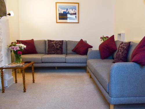 a living room with two couches and a table at Woodville in Porthmadog