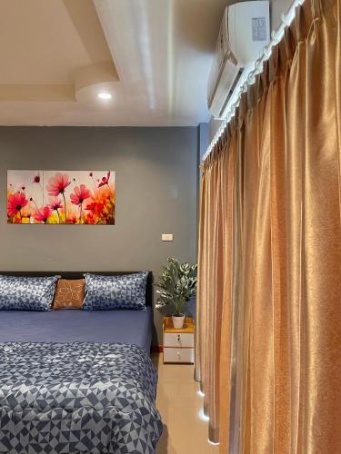 a bedroom with a bed and a curtain at Pluemjai mansion in Ban Kathu