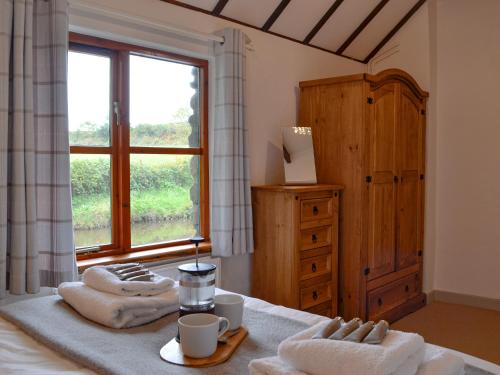 a bedroom with a bed with towels and a window at Mallard in Llangennith
