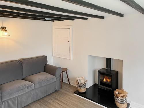 un soggiorno con divano e camino di Lawns Cottage a Helmsley