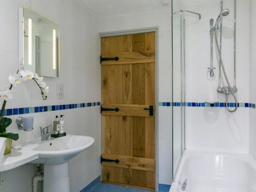 a bathroom with a sink and a shower and a tub at Mallard in Llangennith