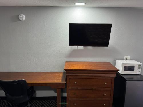 コロンバスにあるBudgetel Inn & Suitesのデスク(電子レンジ付)、壁掛けテレビ