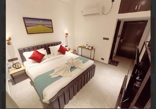 a bedroom with a large bed with red pillows at Gorgeous villa near Eden beach in Puducherry