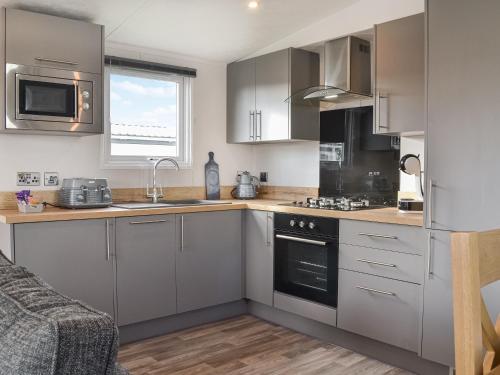 a kitchen with stainless steel appliances and a couch at Atmospheric in Patrington