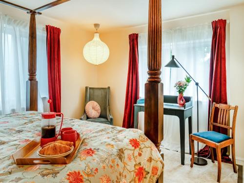 a bedroom with a bed with a tray of food on it at The Coach House in Southwell