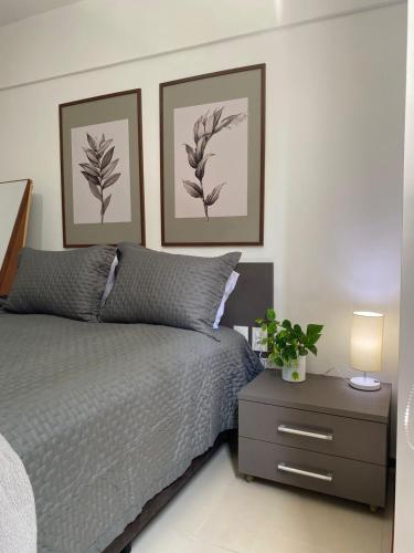 a bedroom with a bed and two pictures on the wall at Flat Costa Nova VIP - em Ponta Verde - Apartamento 202 - 1 Quarto - Proximo a Praia in Maceió