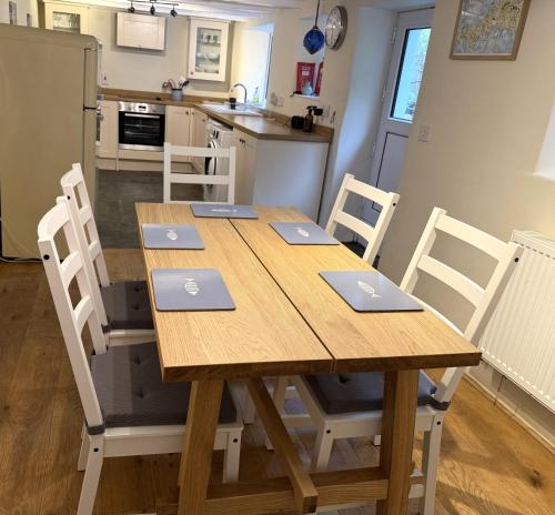 a wooden table with laptops on top of it in a kitchen at 1 Rock Cottages in Treknow