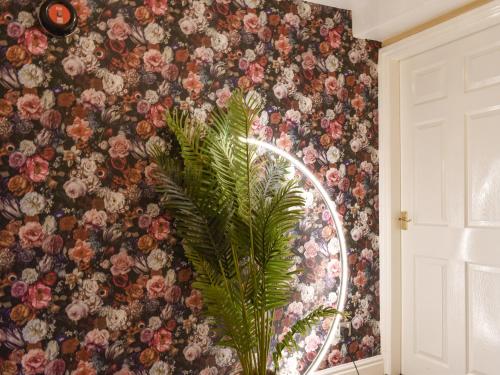 a wall with a floral wallpaper with a mirror at West View Apartment in Bowness-on-Windermere