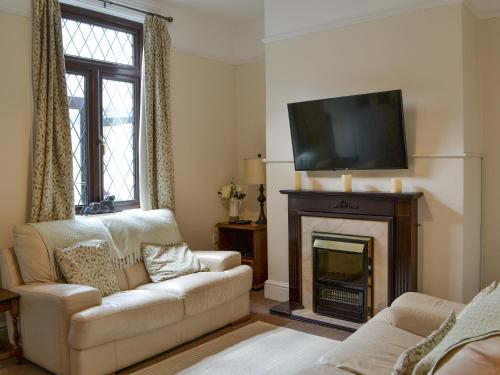 a living room with a couch and a fireplace at Molly's Place in Filey