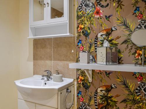 a bathroom with a sink and a monkey wallpaper at The Store - Uk47539 in Newcastleton