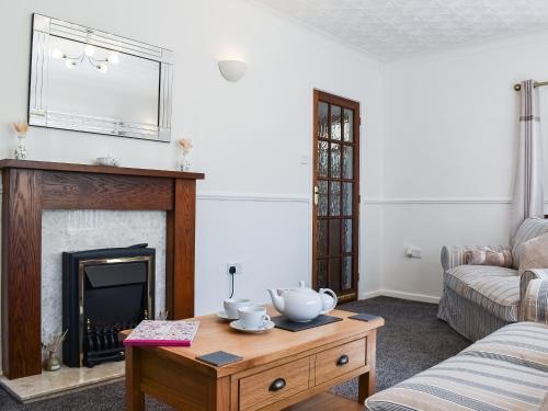 a living room with a fireplace and a coffee table at Ballyholme in Skelton