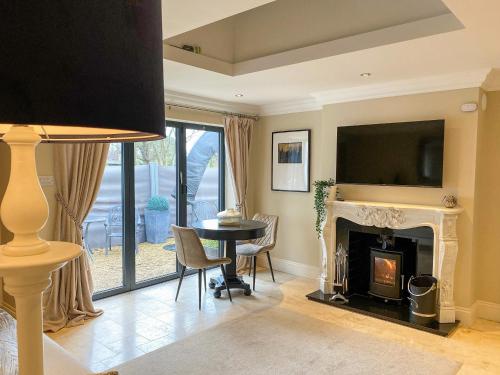 a living room with a fireplace and a tv at The White House Retreat in Findon