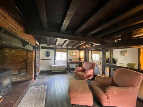 a living room with two chairs and a fireplace at Dairy Farm in Sherfield English