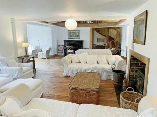 a living room with white furniture and a fireplace at North Barn in Tolpuddle
