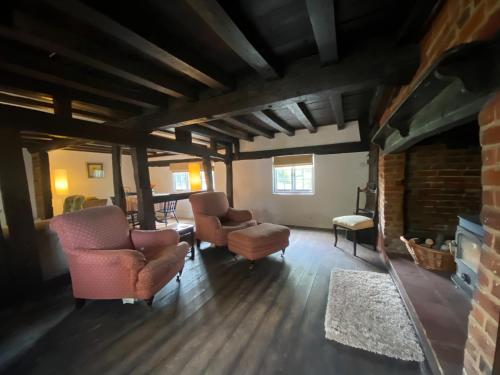 a living room with two chairs and a fireplace at Dairy Farm in Sherfield English