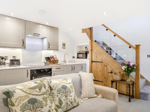 een woonkamer met een bank en een keuken bij Dukes Cottage - Uk47495 in Waterfall