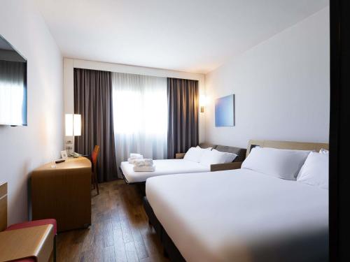 a hotel room with two beds and a window at Novotel Caserta Sud in Caserta