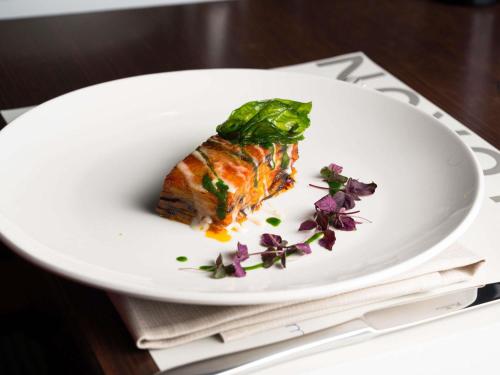 a white plate with a piece of food on a table at Novotel Caserta Sud in Caserta