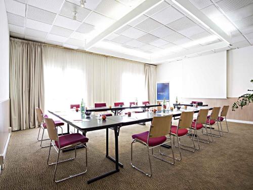 a conference room with a long table and chairs at Novotel Caserta Sud in Caserta