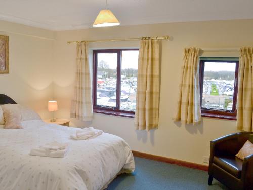 a bedroom with a bed and two windows at Marina Vista in Horning