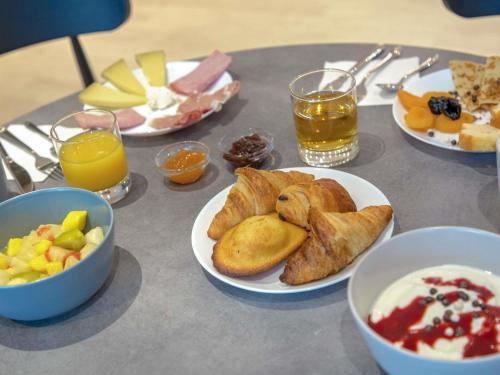a table topped with plates of food and drinks at ibis Styles Cannes Le Cannet in Cannes