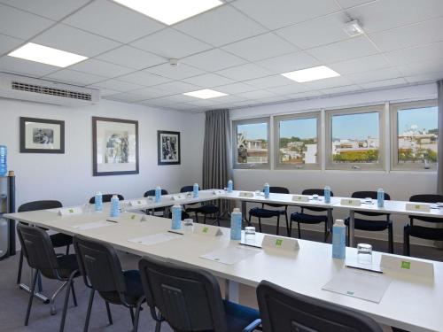 a large room with tables and chairs and windows at ibis Styles Cannes Le Cannet in Cannes